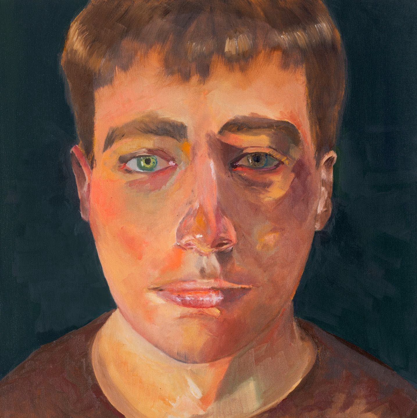 portrait of a young man with green eyes, lit warmly from the left against a deep green ground